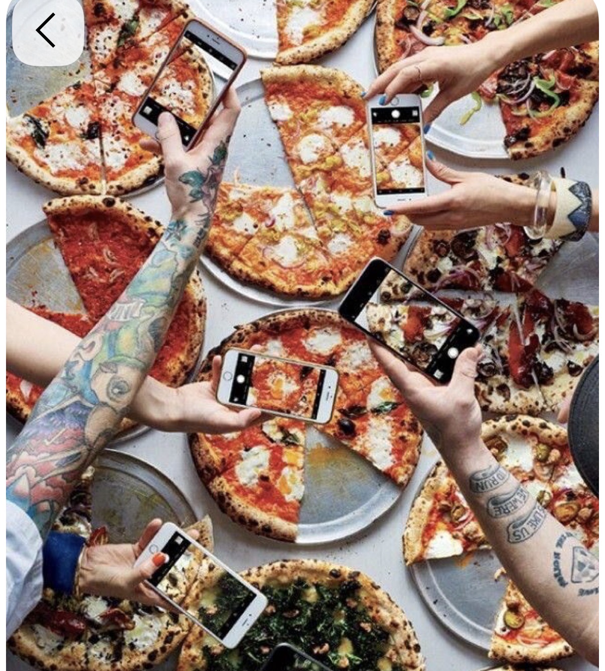Overhead pizza table with tattooed arms and friends photographing the pizzas